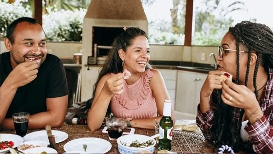 friends enjoying a meal together indicating that someone can be struggling and still enjoy aspects of life.