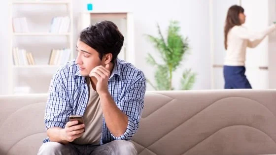man looking sketchy about hiding something on his phone from his partner.