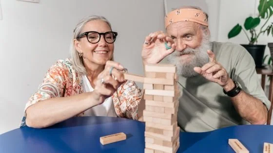 older couple doing Jenga game indicating letting go of the outcome of experimenting with a couples intensive.