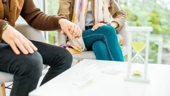 couple holding hands in therapy setting indicating getting help through transitions when needed.