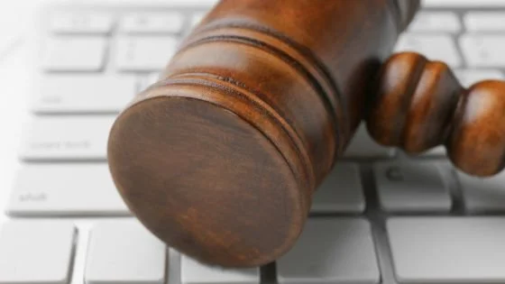gavel on a keyboard satirizing using AI as a judge and jury.