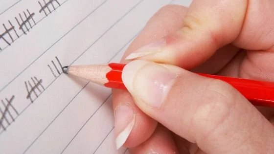 person tallying on paper indicating score keeping in a relationship. How to find equity in a relationship can be learned in couples counseling.