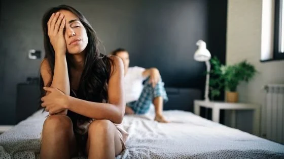 woman looking overwhelmed at the end of bed indicating pressure to do the relationship right.