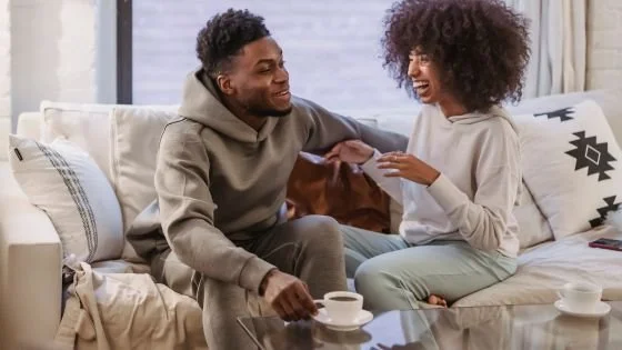 couple talking animatedly on couch, indicating slowing down and listening to each other.