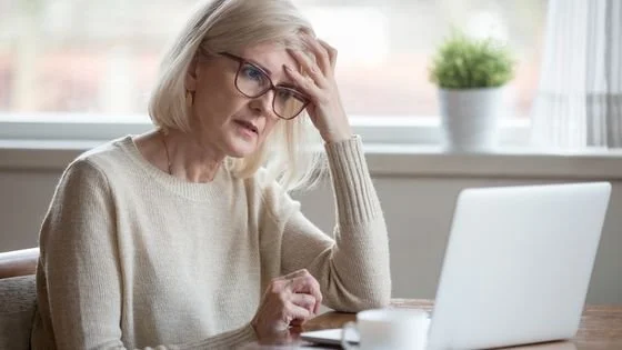 woman at her computer looking frustrated because she's trying to us AI to identify if her partner is a narcissist, which is not a helpful tool for diagnosis.