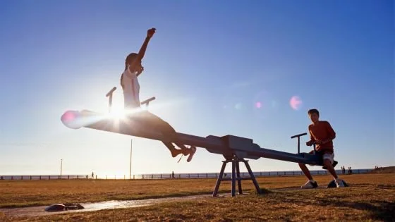 couple on seesaw symbolizing initiating repair balancing out