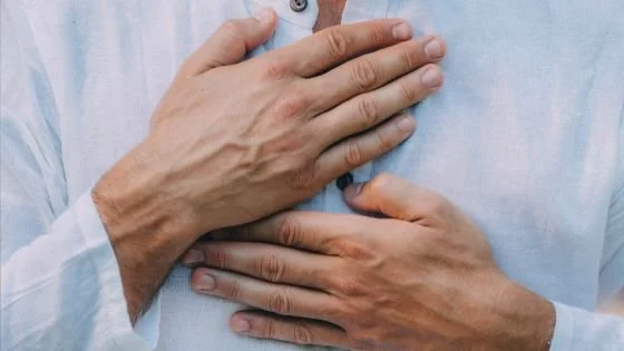 man with hands on heart symbolizing self-compassion and being gentler with oneself.