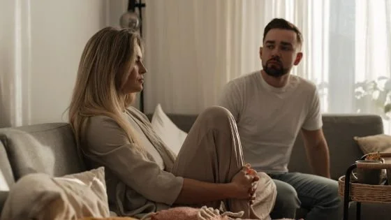 couple on couch looking distant and upset indicating the value of how we can honor the relationship ending in couples therapy.