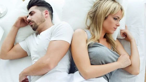 couple turned away from each other in bed indicating looking like avoidance in conflict actually being emotional flooding