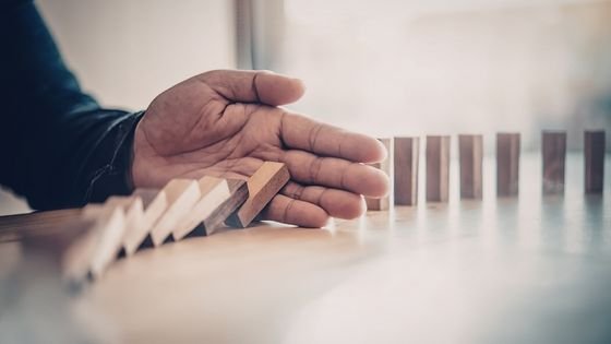 hand blocking falling blocks indicating stalling momentum.