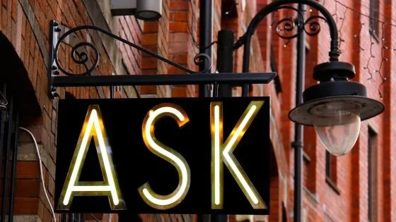 sign that says "ask" indicating the importance of curiosity when trying to understand a partner's sexual experience.