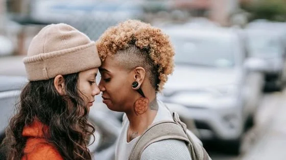two women with foreheads touching recognizing the sovereignty of their humaness and accepting each other in pain.