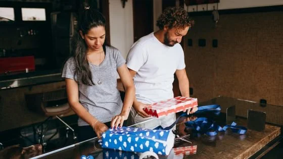 detached couple wrapping presents next to each other.