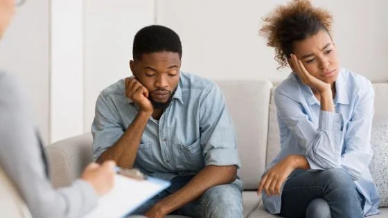 couple looking despondent on therapy couch indicating being there while not making progress, our first busted myth.