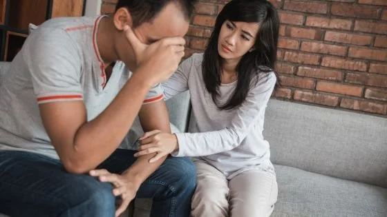 woman comforting man who is flooded