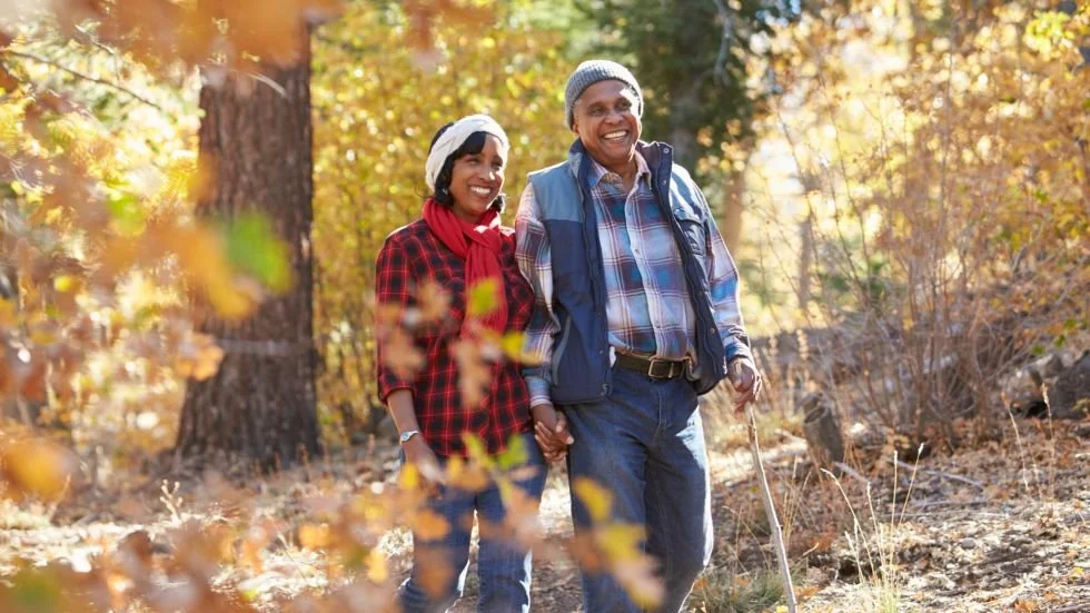 depicts older black couple walking in the wood to illustrate small ways to connect during the holidays