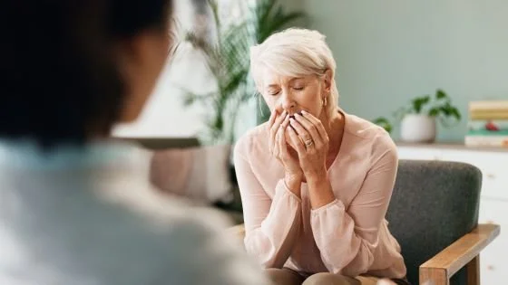 older woman confiding in therapist indicating having a space to process.
