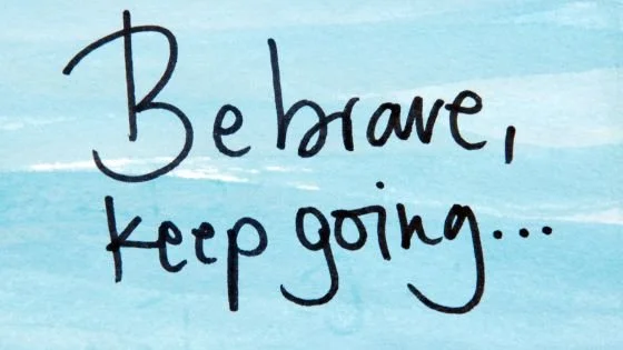 watercolor background with handwritten "Be brave, keep going" related to forward momentum.