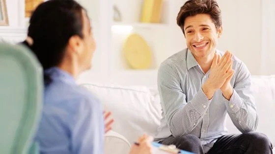 male clients smiling and laughing with his female therapist. Indicates being relational and being a human with our clients.