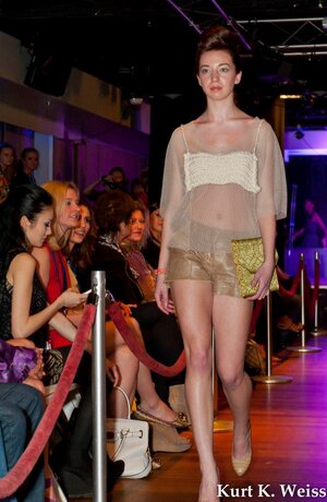 Model walks Knoxville Fashion Week 2016 runway in sheer white top and leather shorts
