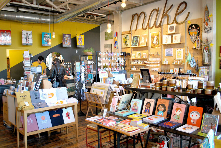 The interior of Rala, hardwood tables and many shelves hold local art and handmade good 