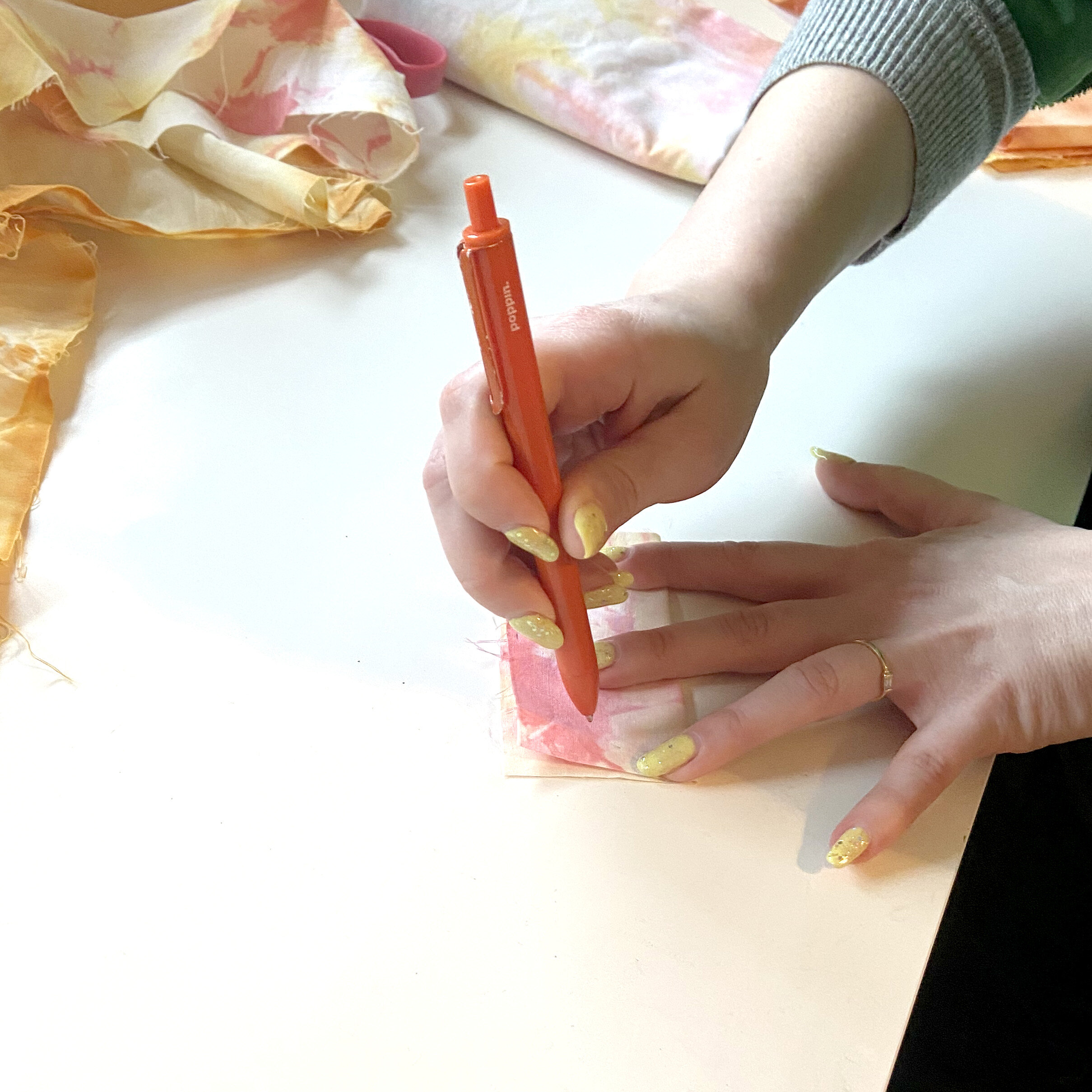 Alaina uses an ink pen to outline shape of cat toy on fabric