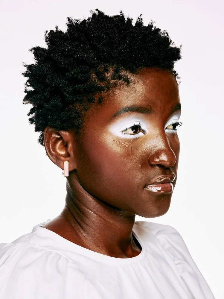 A woman wears the Geometric Long Bar Studs in Rose Quartz.