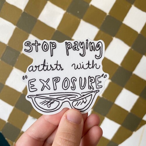A black and white sticker designed by Paris Woodhull that reads “stop paying artists with exposure“. photo via ParisWoodhull.com.