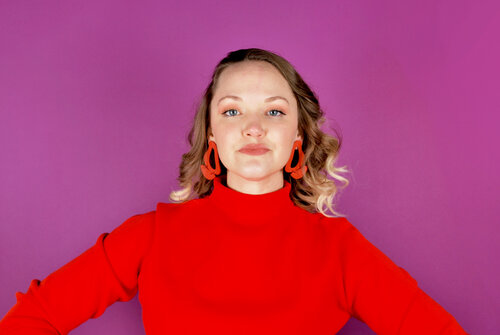 Alaina rocking a bright red mock neck sweater with red Cold Gold inferno earrings.