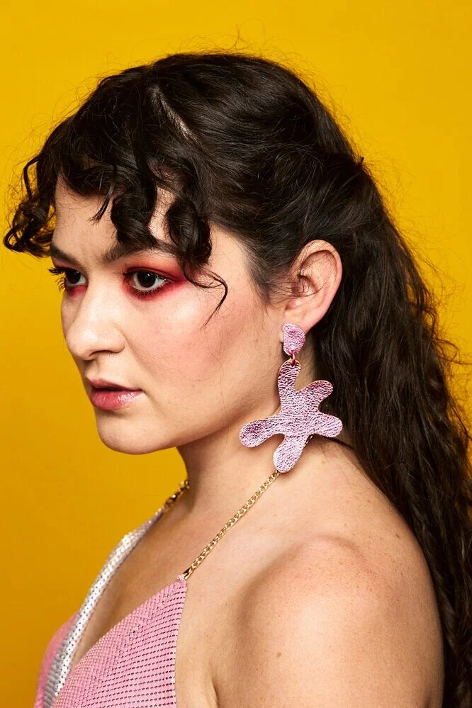Shining metallic pink star-shaped leather earrings are a fun birthday gift for your Aquarius friend.