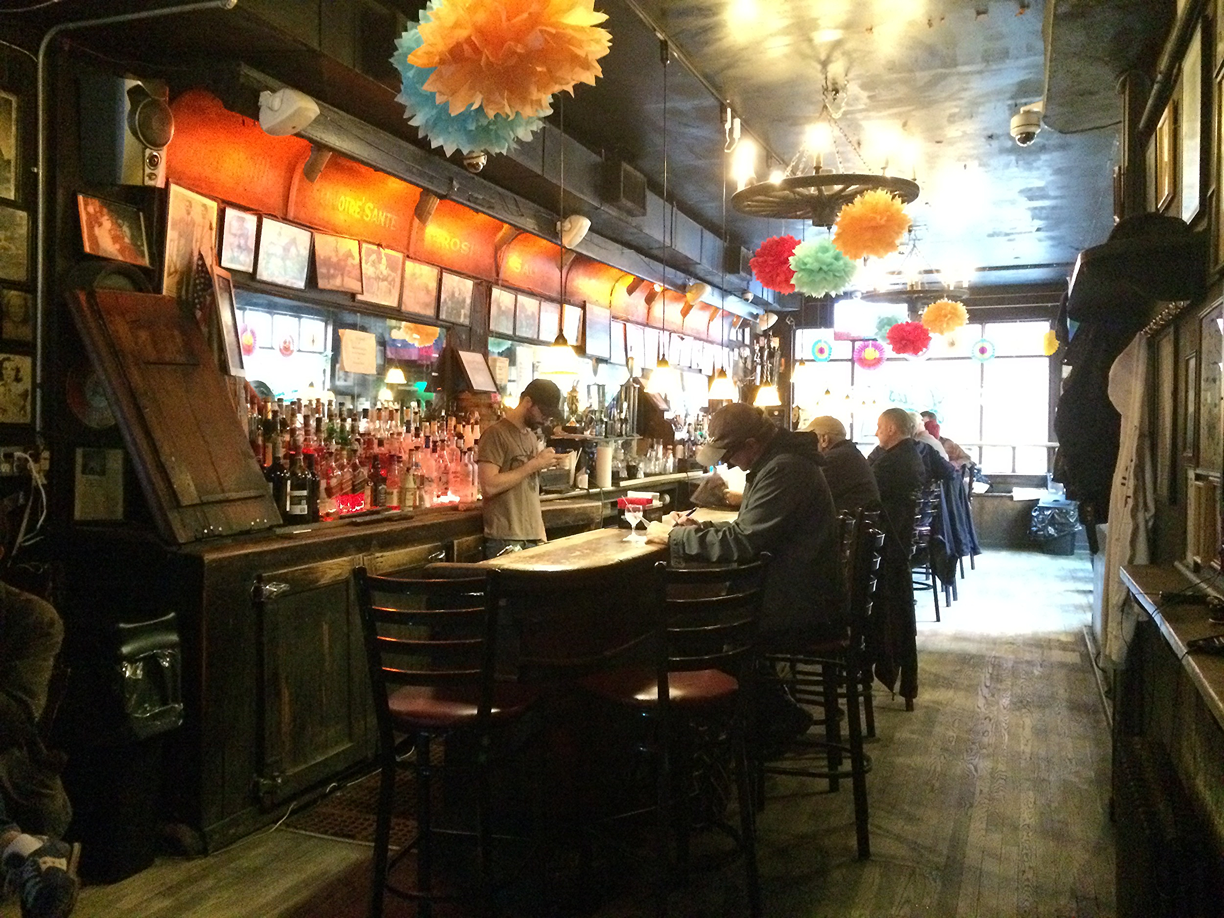 pom poms&nbsp;hanging from the wagon wheel chandeliers on a monday in late may (not a normal fixture). the grill man speculated they were left up from cinco de mayo, or maybe just for spring, but nobody knew for sure.&nbsp;