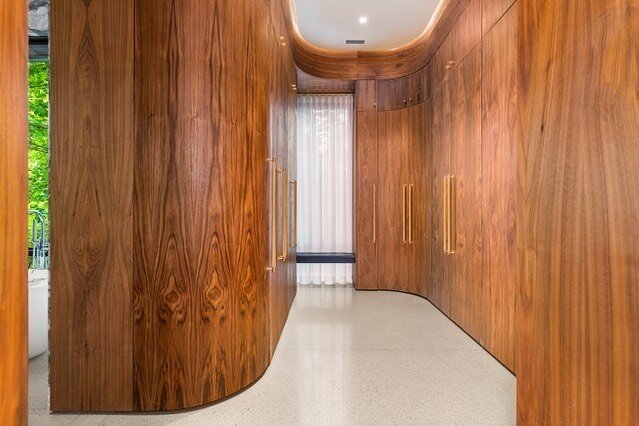 A unique walk-in closet built off of the principle bedroom. This room is a perfect blend of form and function with its elegant drop down ceiling and light cove above the curved walnut cabinetry. One of the many standouts featured in this home. 

@gre