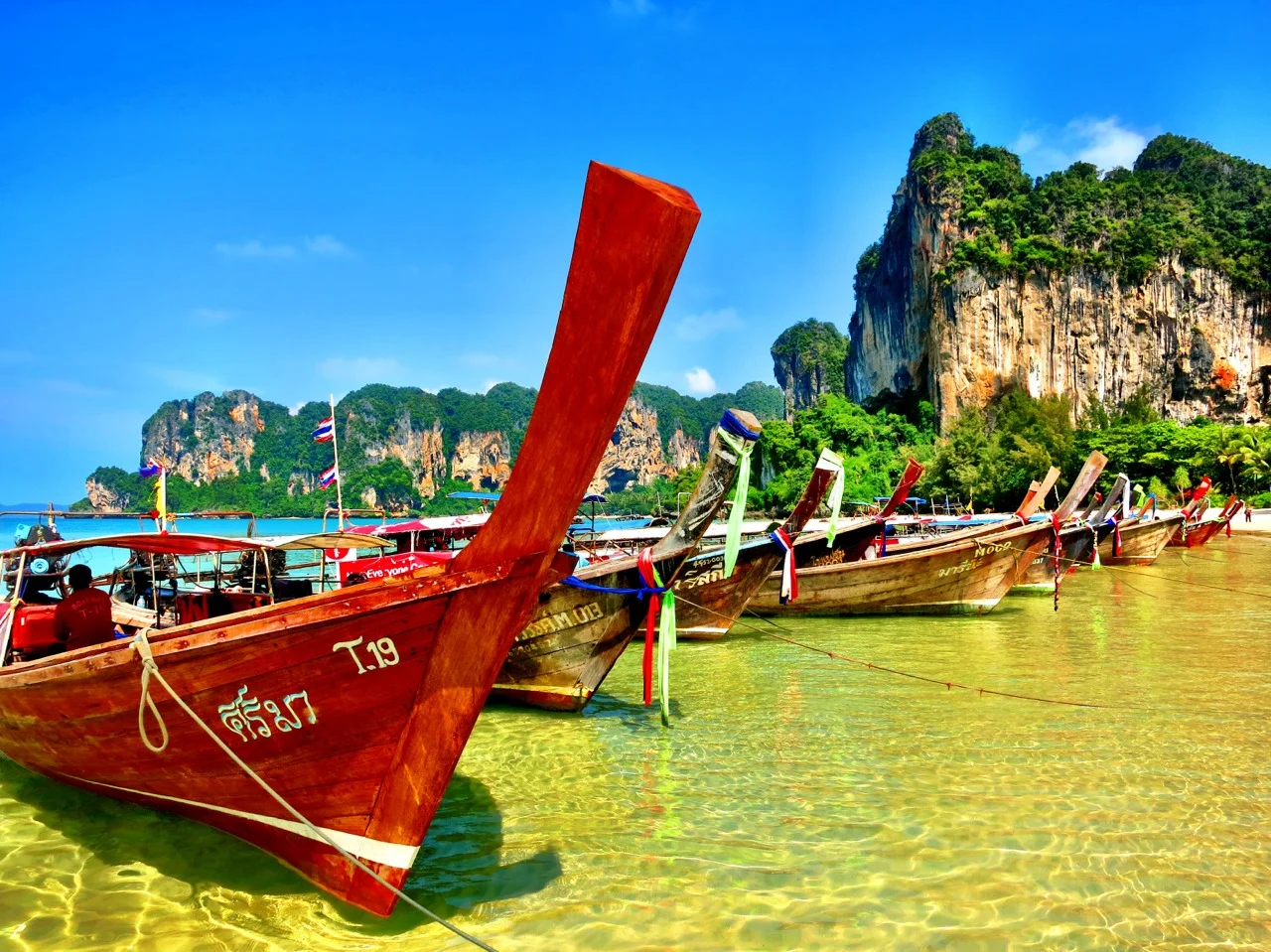 Long boats line up on Railay West beach.