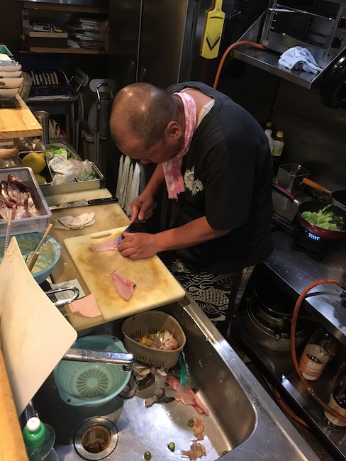 The scene on the other side of the counter of a lively izakaya in Hiroshima