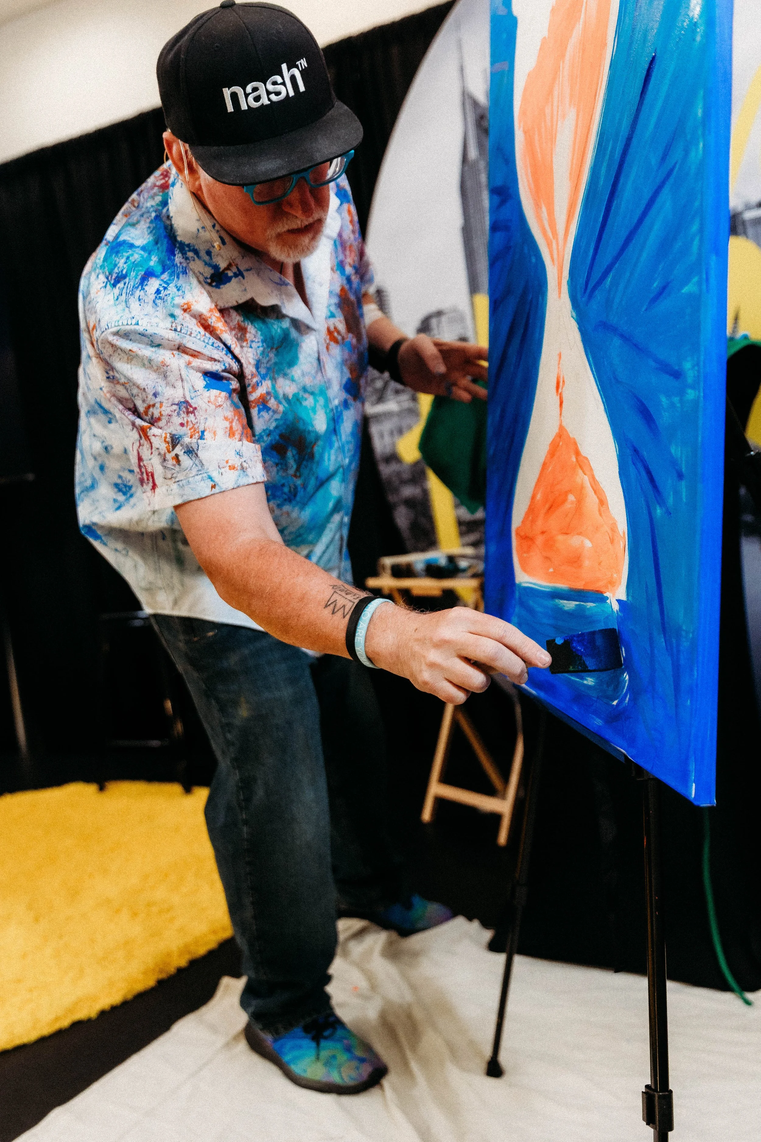 Artist and Speaker Mike Brennan speaking and live painting on stage.