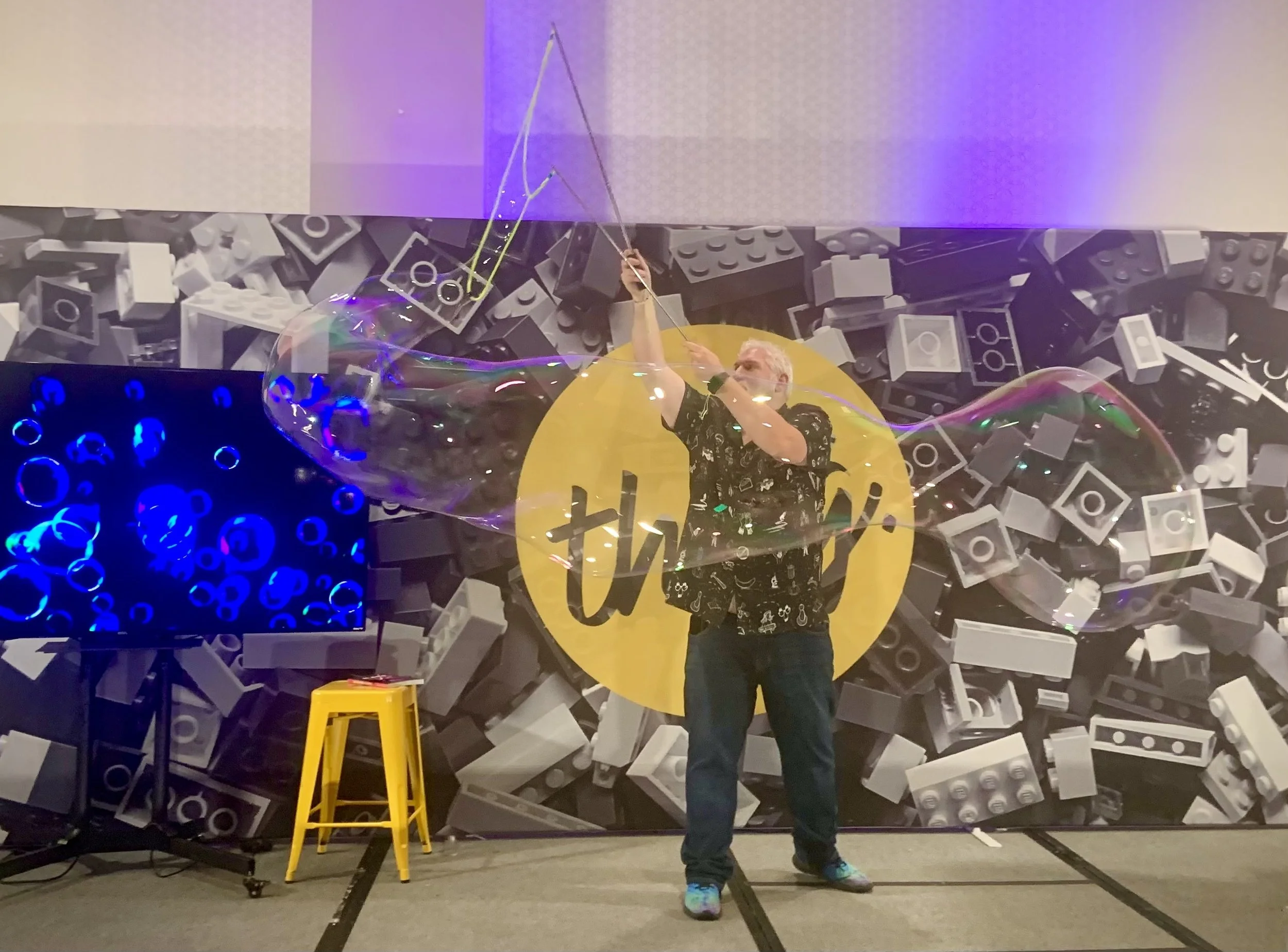 Mike Brennan speaking at The Thing event, making huge bubbles on stage.