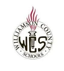 Williamson County Schools logo featuring a torch with red flames and the initials 'WCS' inside a circular design.