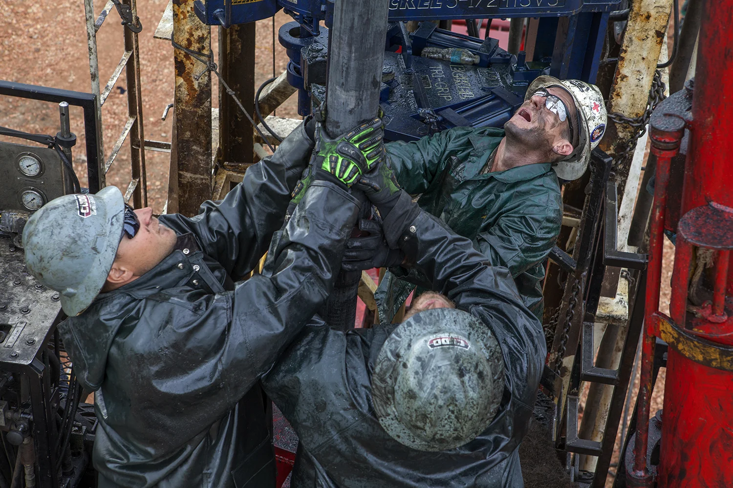 Oil workers remove and replace pipes on a workover rig Epping, ND. 2012