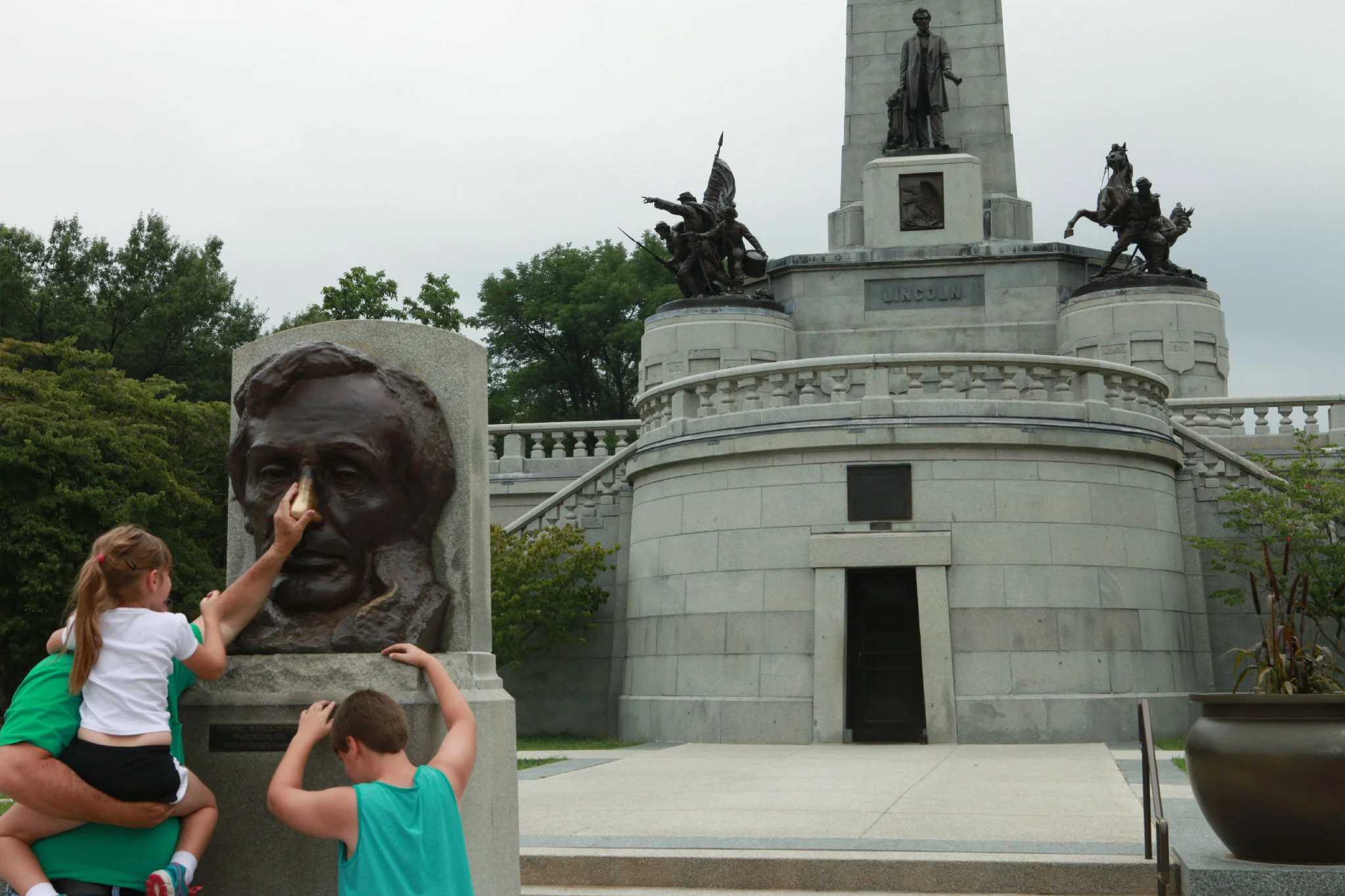 Tourists rub Lincoln's worn, bronze nose for good luck Oak Ridge Cemetery Springfield, IL. 2014