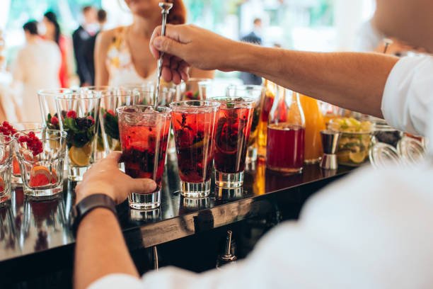  Hand making red cocktail at the open-air wedding party. 