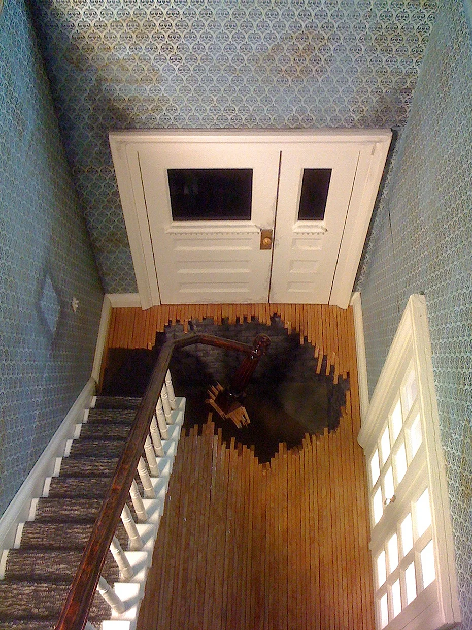 'Tom Ridge' Main Vignette-Sinkhole Detail Wood framing, Metal mesh, Mahoghany Handrail, Moving Blankets, Cart, Fiberglas Insulation, Metal Floor Grates, Cast Iron Window Weights, Audio Approx: 18’L x 3’W x 12’H 2014