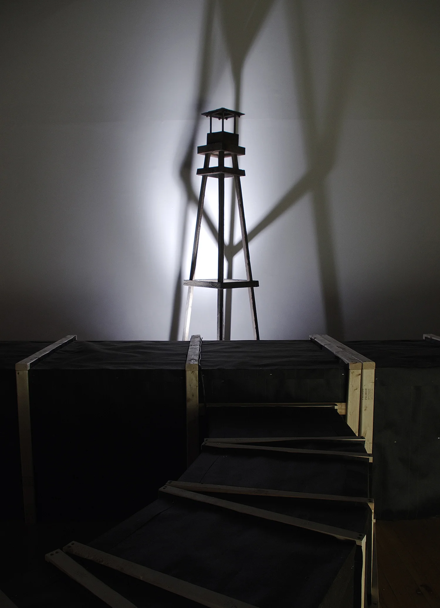 ‘Beneath / Suspicion' Detail at Exterior Guard Tower Wood framing, oak pallet wood, drapery, nightlights, kiln-burned pine tar, incense, muslin. glass view lenses, fiberglas insulation, audio track. Tunnel Portion- 3’W x 2’-8”H x approx. 120’L 2013 Image credits: Gordon Pellegrinetti.