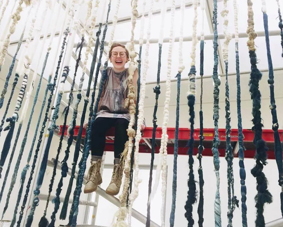 Sarah Bendix installing wool pieces hand-dyed with indigo at the Fries Museum in Leeuwarden, The Netherlands, as part of Claudy Jonstra's solo exhibition "Ancient Light."