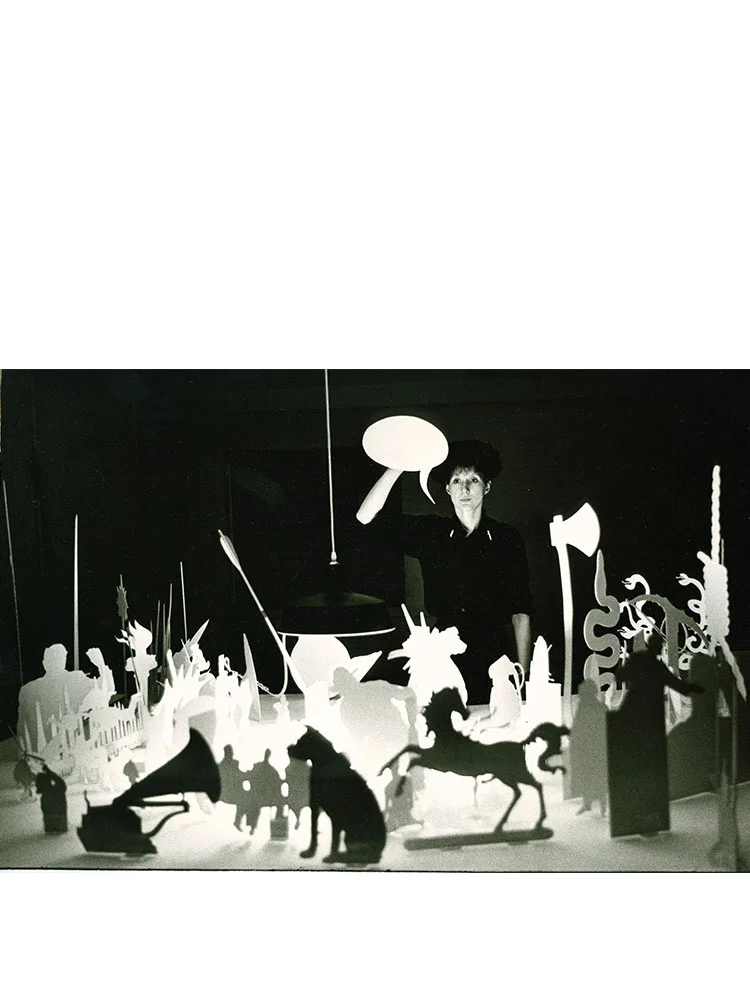 Rose Finn-Kelcey Glory 1983 Card, metal, wood, speakers, sound system, acrylic, arrow, red gloves (A performance involving 100 cardboard cut-out surrogate performers, croupiers shovel, other implements and sound track)