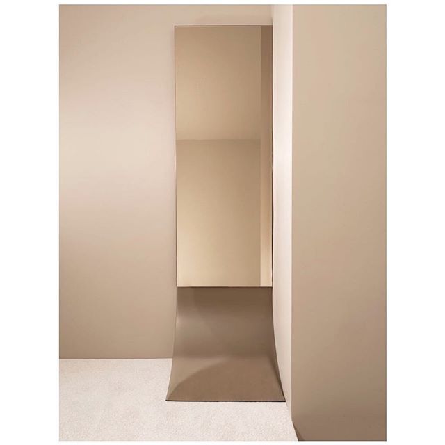 The CYC Mirror is inspired the iconic curved wall used as a backdrop for studio photography. Bronze mirror flows into a panel of acid etch bronze glass expertly bent by @flickingerglassworks