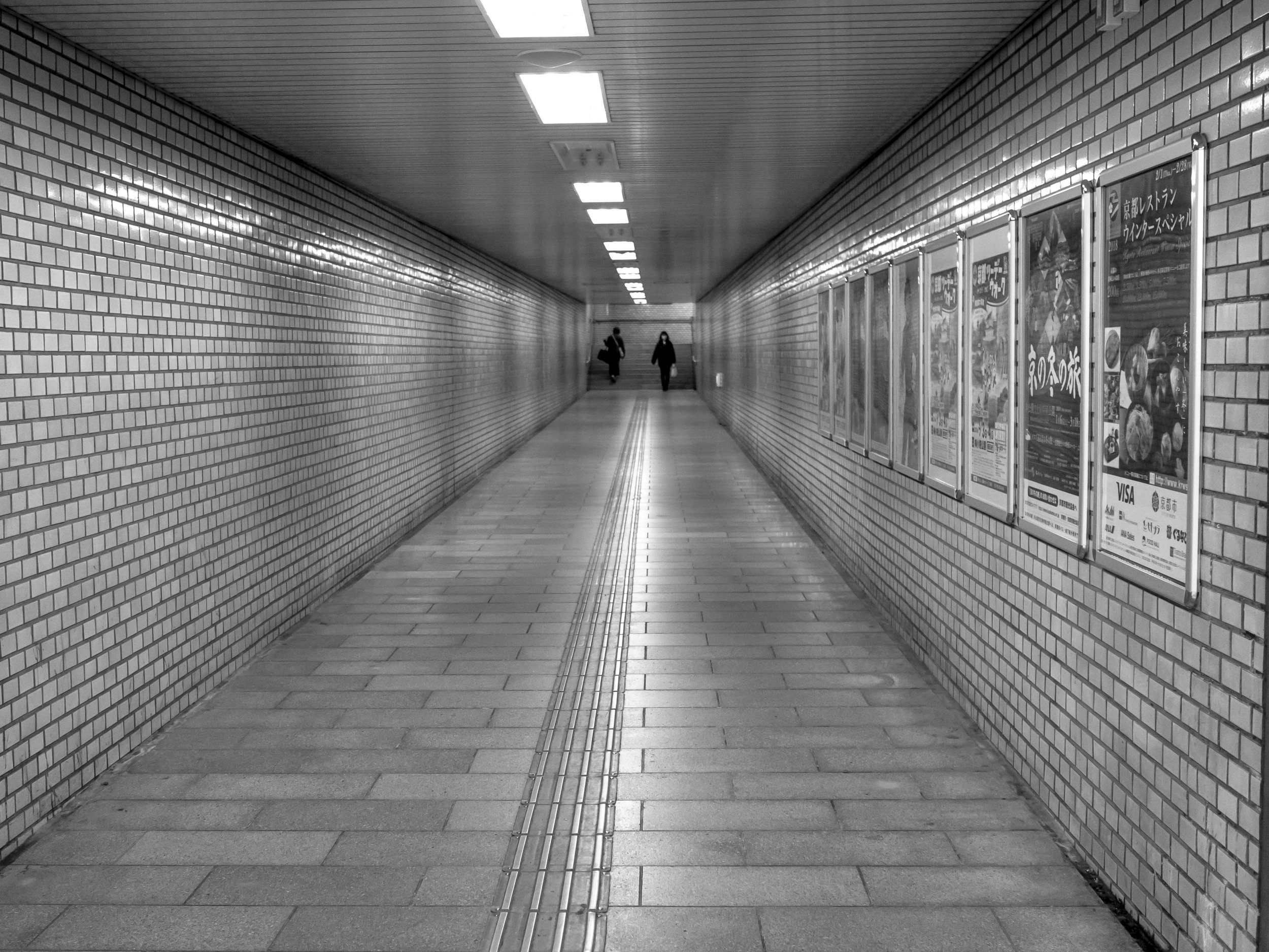 Sometimes, a less fast drop-off Bokeh is desired. The lens that took this image as focussed (by mistake) at 2 meters and f2 aperture was selected (you can see the point of best focus is the first poster). The Bokeh characteristic of the lens was a more old fashioned "long transition" or coherent Bokeh, not as popular as the smooth and fast drop-of of most modern lenses, but very useful when the focus misses or DoF is limited. The people in the background are still clearly formed even though they are well out of focus and the transition from fully sharp to out of focus is almost invisible. Other lenses in the same situation (like the one used for the image above) may tend to make anything past the point of focus quickly look blobby or smeared and make this image pointless.