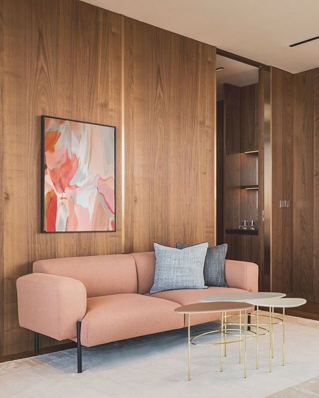 A cozy living room corner in the master suite.
.
The room is wrapped in walnut timber for the wall and floor with anodized copper accent. The furnishings were chosen in shades of blush to compliment the palette of the home.