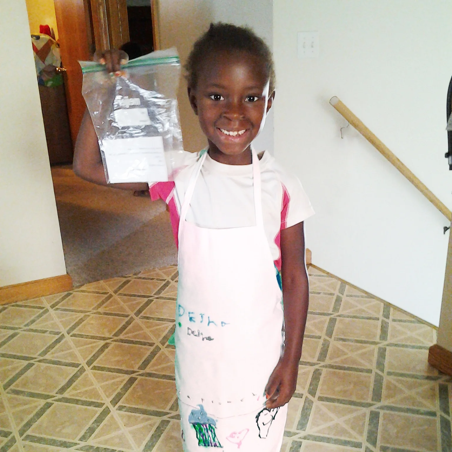 Dehja (age 6) is ready to cook with her apron on and recipe in hand!