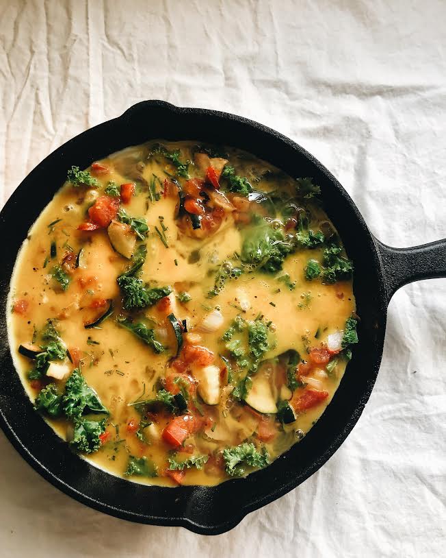 pour egg mixture over vegetables and cook until edges start to set