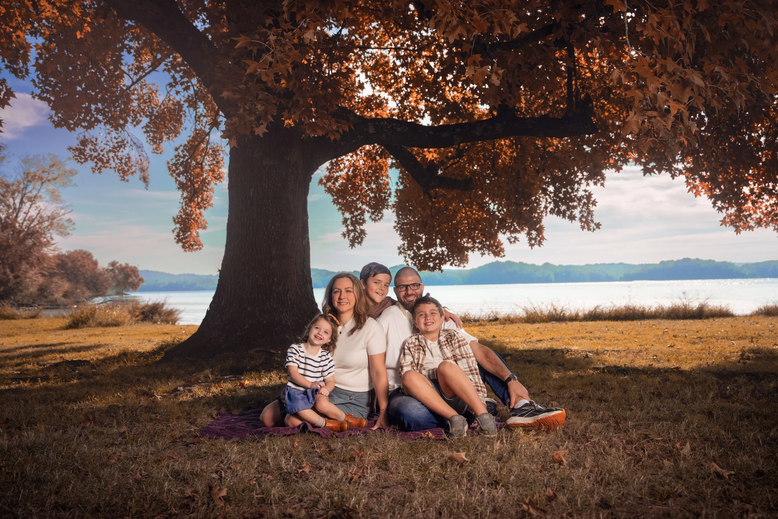 Family portrait beneath a large autumn tree beside the lake, photographed by Matt and Shea Photography in Chattanooga, Tennessee